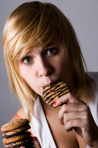 Mujer comiendo galletas con chispas de chocolate — Foto de Stock