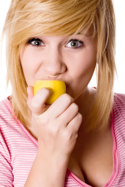 Девушка ест лимон — стоковое фото