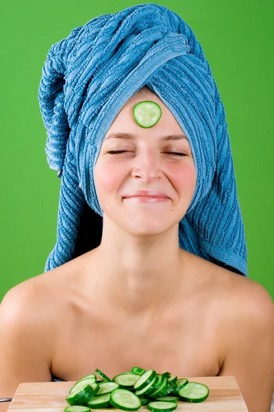 Leende kvinna i blå handduk och mask från gurka — Stockfoto