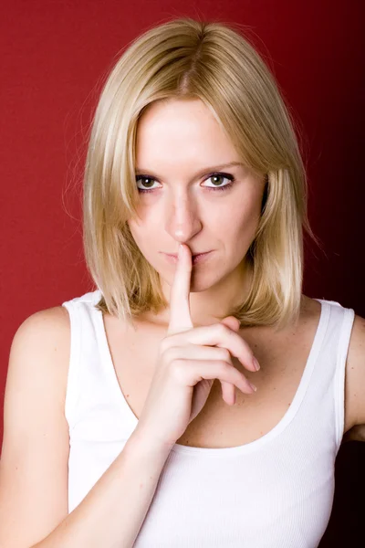 Vrouw met vinger op de lippen — Stockfoto