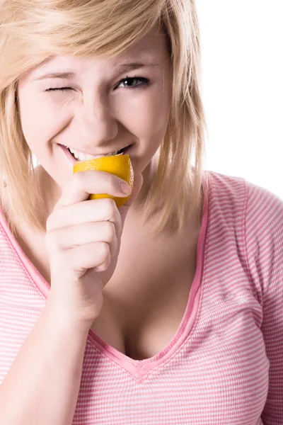 Mladá dívka jíst citrón — Stock fotografie