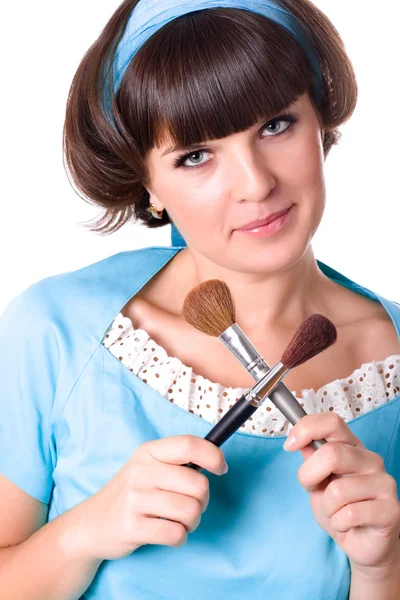 Mulher de vestido azul com duas escovas de maquiagem — Fotografia de Stock