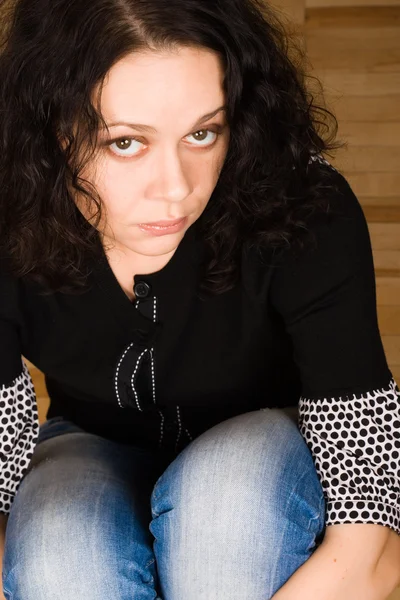 Frau sitzt auf einem Holzboden — Stockfoto