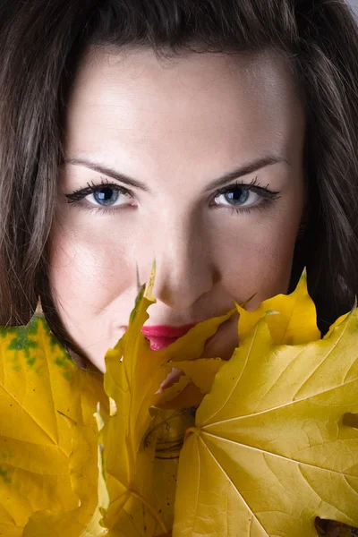 Młoda kobieta z żółtymi liśćmi — Zdjęcie stockowe