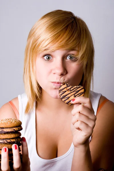 Vrouw eten chocolade chip cookies — Stockfoto