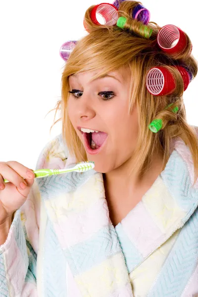 Grappige huisvrouw met krulspelden en tandenborstel — Stockfoto