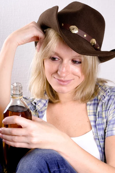 Женщина-ковбой с бутылкой виски — стоковое фото