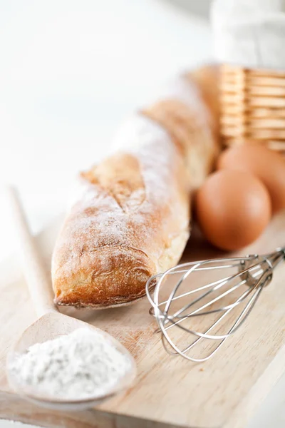Natura morta di pane, farina, uova e utensili da cucina — Foto Stock