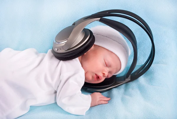 stock image The newborn kid listening to music