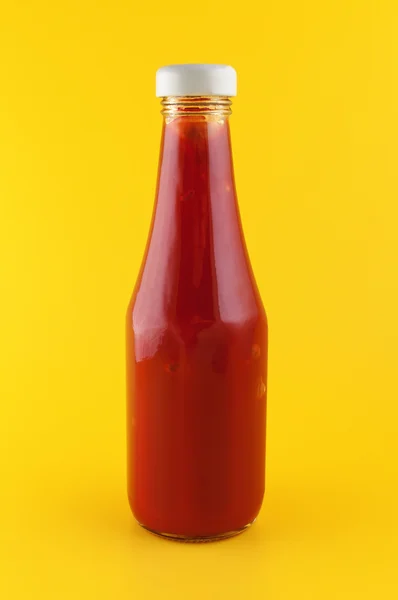 Ketchup in a bottle on yellow background. — Stock Photo, Image