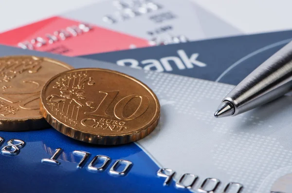 Kreditní karty a mince s perem. — Stock fotografie