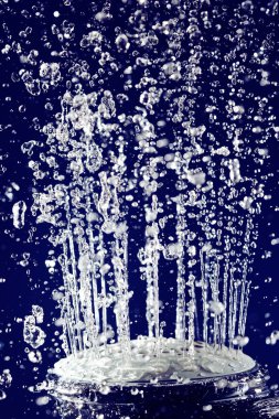 Hand shower douche with stopped motion water drops on deep blue clipart