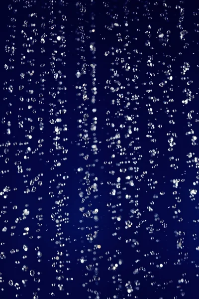 Gestopt beweging waterdruppels achtergrond op donkerblauw — Stockfoto