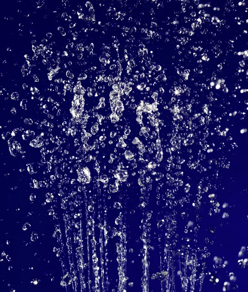 Air yang berhenti tetes latar belakang pada biru tua — Stok Foto