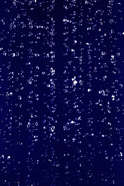 Gestopt beweging waterdruppels achtergrond op donkerblauw — Stockfoto