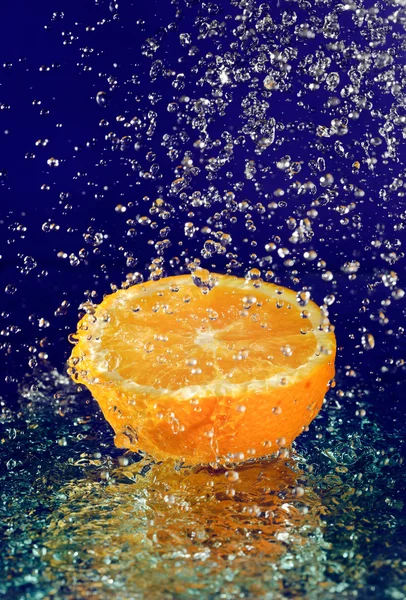 Half of orange with stopped motion water drops on deep blue — Stock Photo, Image