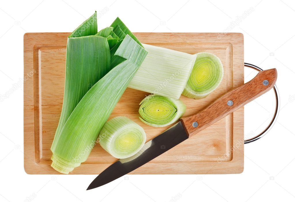 Green leek with knife on wooden chopping board over white backgr
