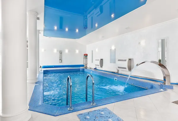 Interior de la gran piscina azul interior en estilo minimalista moderno Fotos de stock libres de derechos