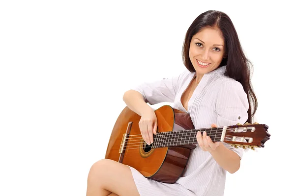 Fiatal gyönyörű mosolygós barna hölgy fehér hálóing lejátszás egy — Stock Fotó