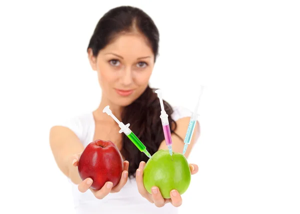 Mujer atractiva joven sosteniendo manzana transgénica con tres jeringas — Foto de Stock