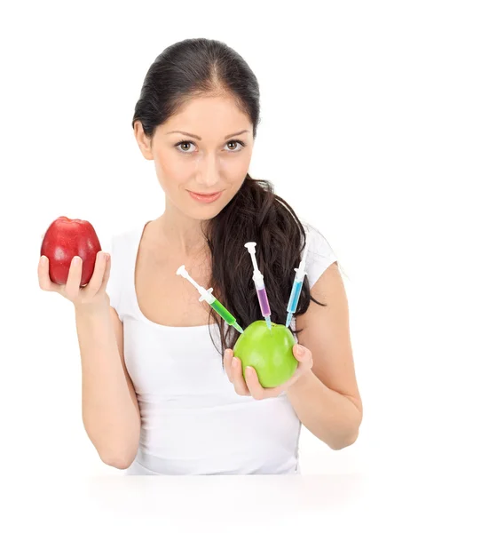 Mujer atractiva joven sosteniendo manzana transgénica con tres jeringas —  Fotos de Stock