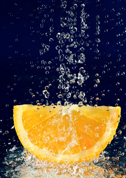 Orangenscheibe Mit Angehaltener Bewegung Wassertropfen Auf Tiefes Blau — Stockfoto