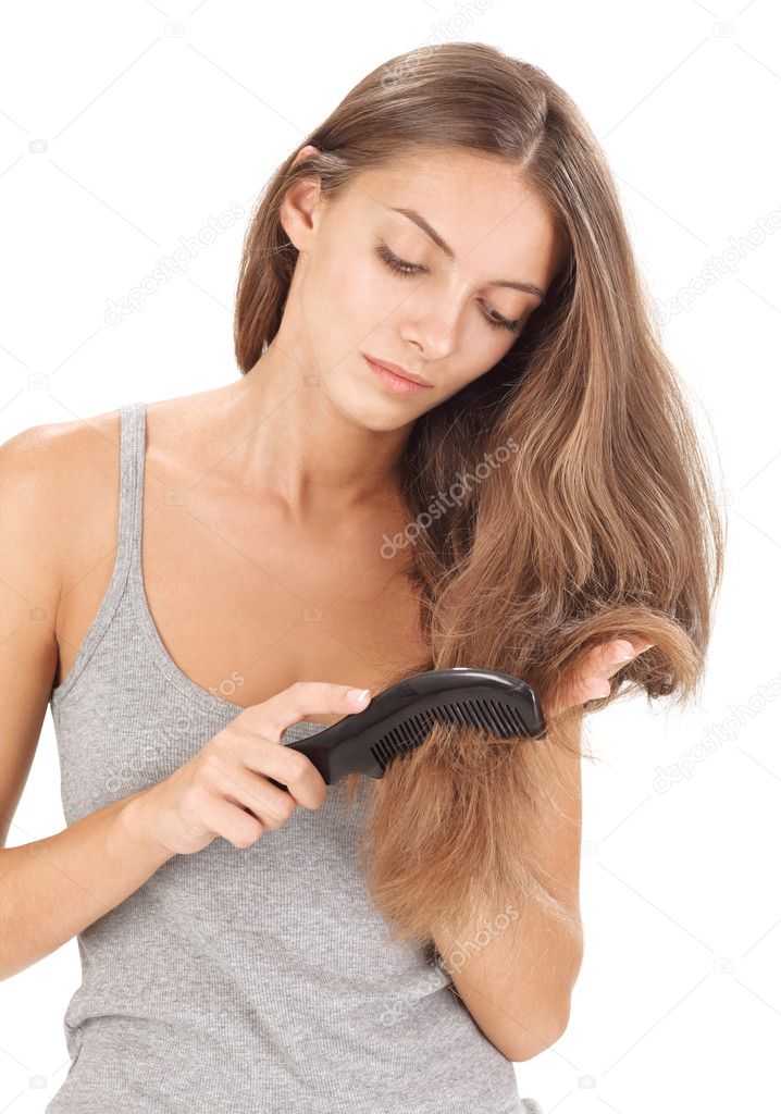 Young brunette beautiful lady combing long hairs on white