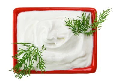 Sour cream in red small square plate with dill twig, isolated on white clipart