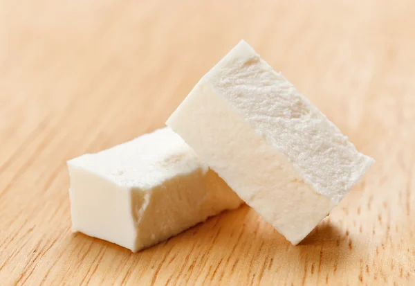 Feta ost kuber med på trä skärbräda — Stockfoto