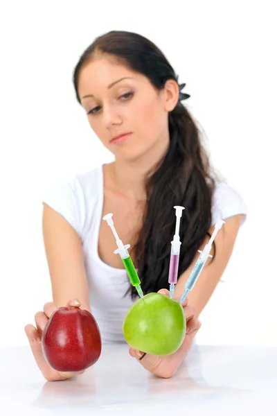 Mujer atractiva joven sosteniendo manzana transgénica con tres jeringas —  Fotos de Stock