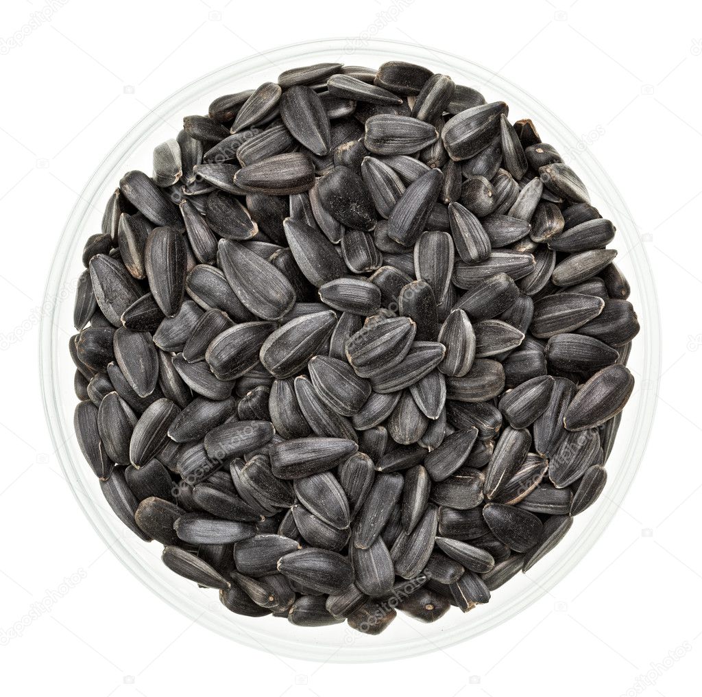 Shelled sunflower seeds in a glass bowl isolated on white
