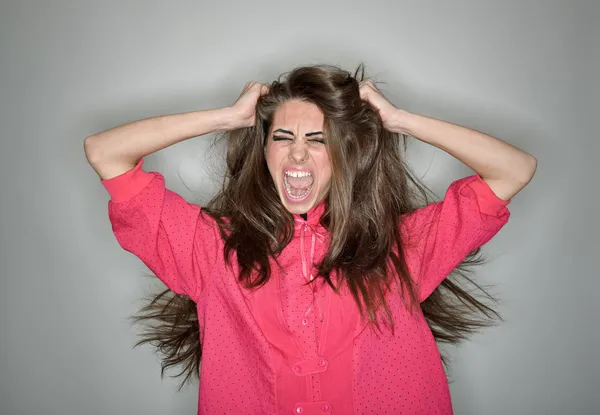 Křičí agresivní bruneta žena v růžovou halenku s — Stock fotografie