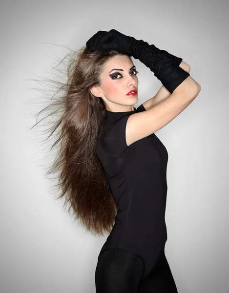 Jonge mooie vrouw in zwarte combi jurk en fluwelen handschoenen hol — Stockfoto