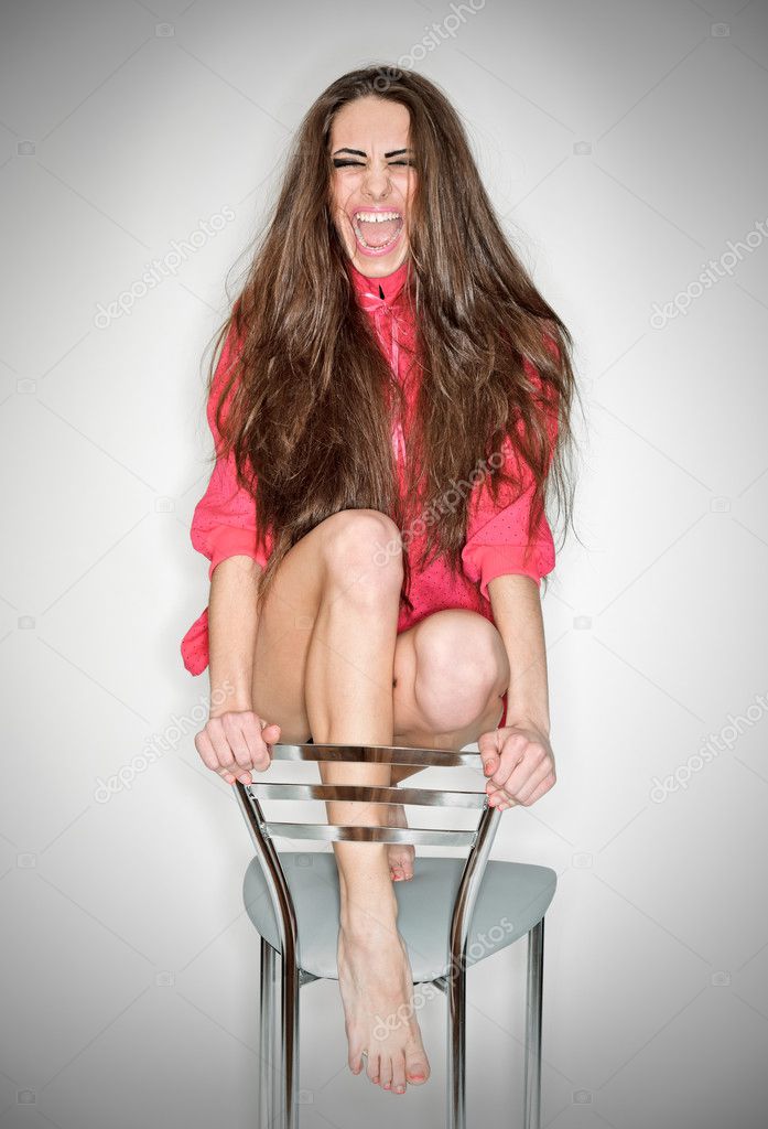 Screaming aggressive emotion woman in pink blouse with long hair