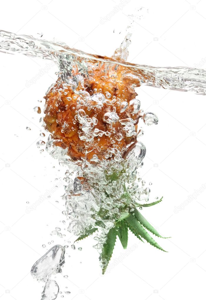 Small pineapple falling in water on white