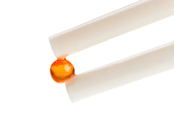 One red salmon caviar ball in chopsticks — Stock Photo, Image