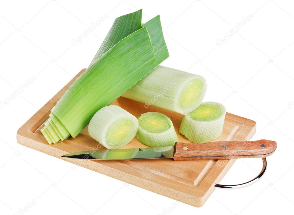 Green leek with knife on wooden chopping board over white backgr