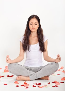 Young beautiful woman meditating in lotus pose clipart