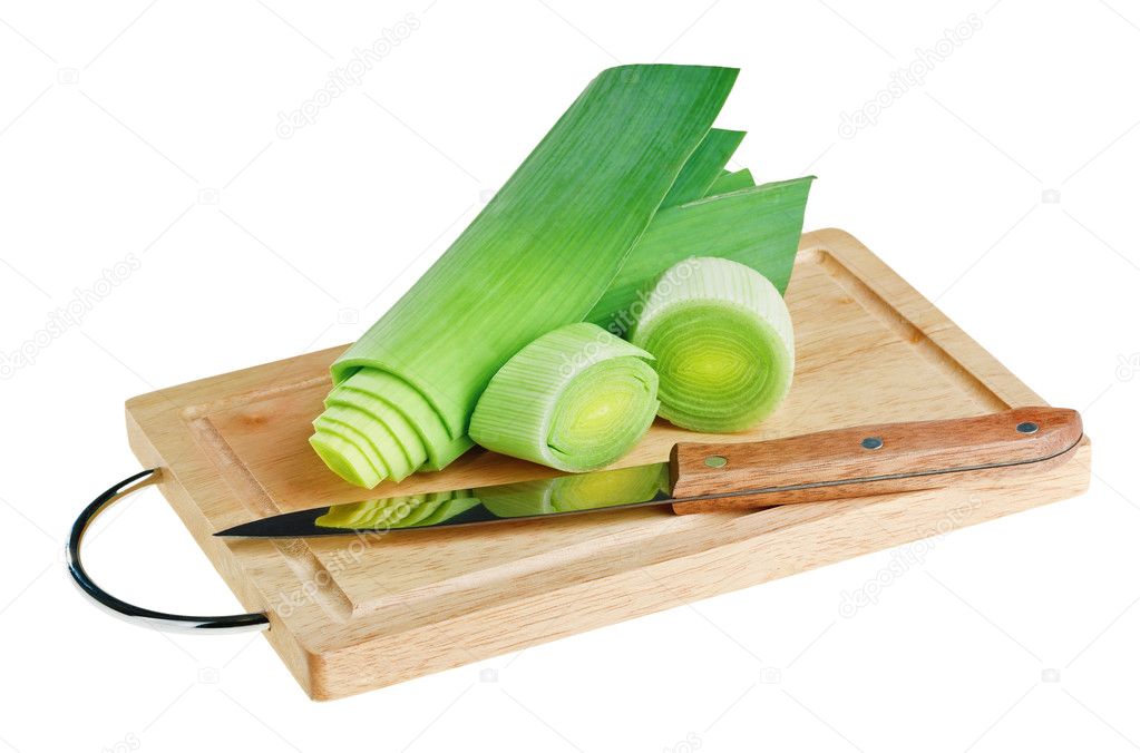 Green leek with knife on wooden chopping board