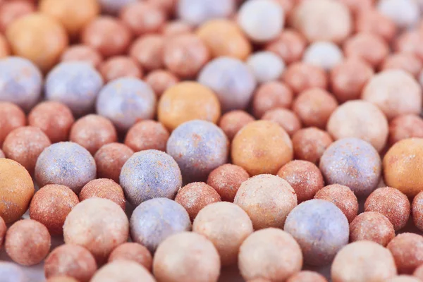 Cosméticos bege bolas ruge multicolor fundo, vista macro — Fotografia de Stock