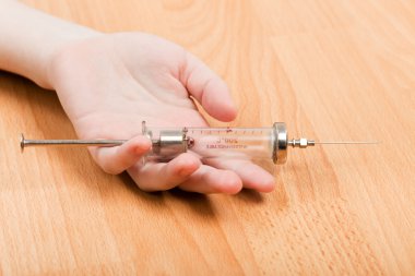 Syringe in addict hand clipart