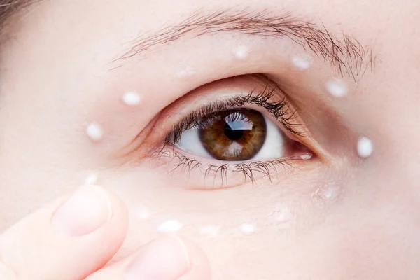 Ženy použití oční krém — Stock fotografie