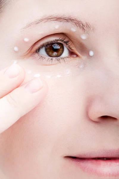 女性の皮膚の目のクリームを適用します。 — ストック写真