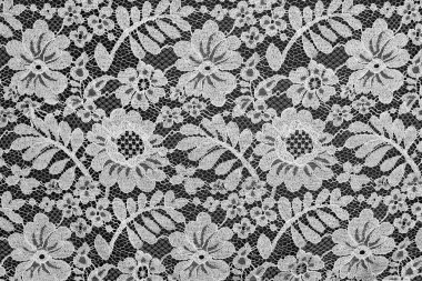 White fine lace floral texture on black background clipart