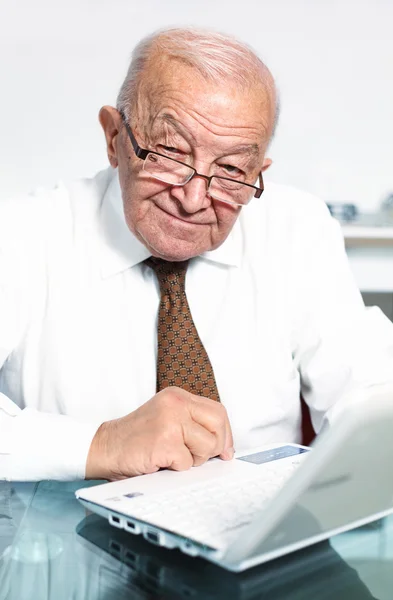 Lachende oude man met laptop — Stockfoto