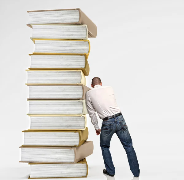Homem empurrar pilha livro — Fotografia de Stock