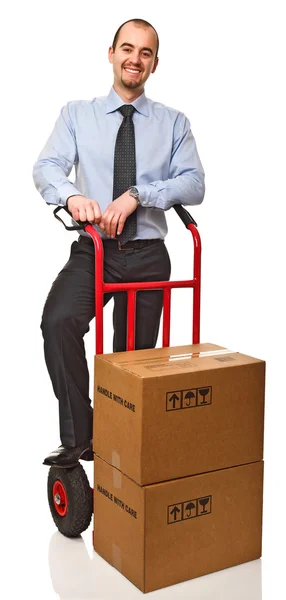 Handtruck とボックスを持つビジネスマンの笑みを浮かべてください — ストック写真
