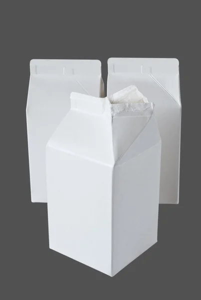 Три коробки молока на пол-литра на сером — стоковое фото