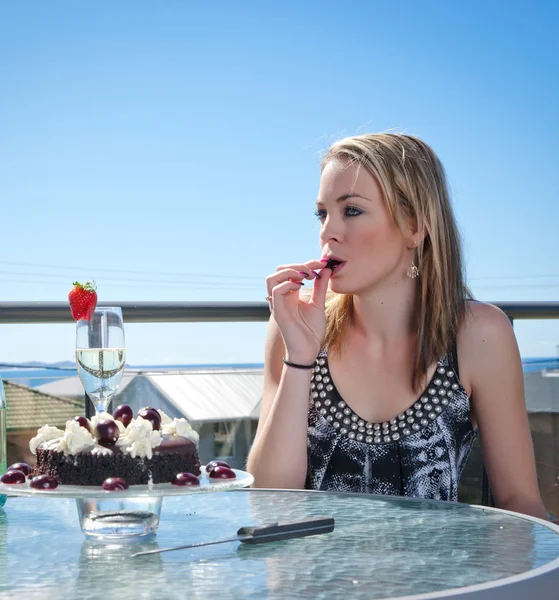 Fiatal nő tortával és pezsgővel — Stock Fotó