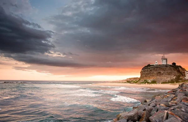 Маяк и закат океана — стоковое фото